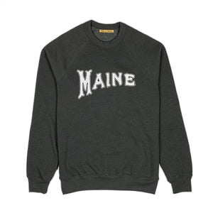 Milo in Maine heather green sweatshirt with 'MAINE' printed on it with white ink