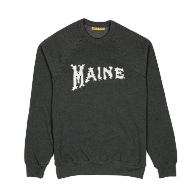 Milo in Maine heather green sweatshirt with 'MAINE' printed on it with white ink